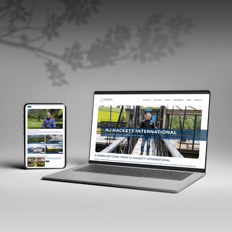 Laptop and tablet showcasing the AJ Hackett International website design.